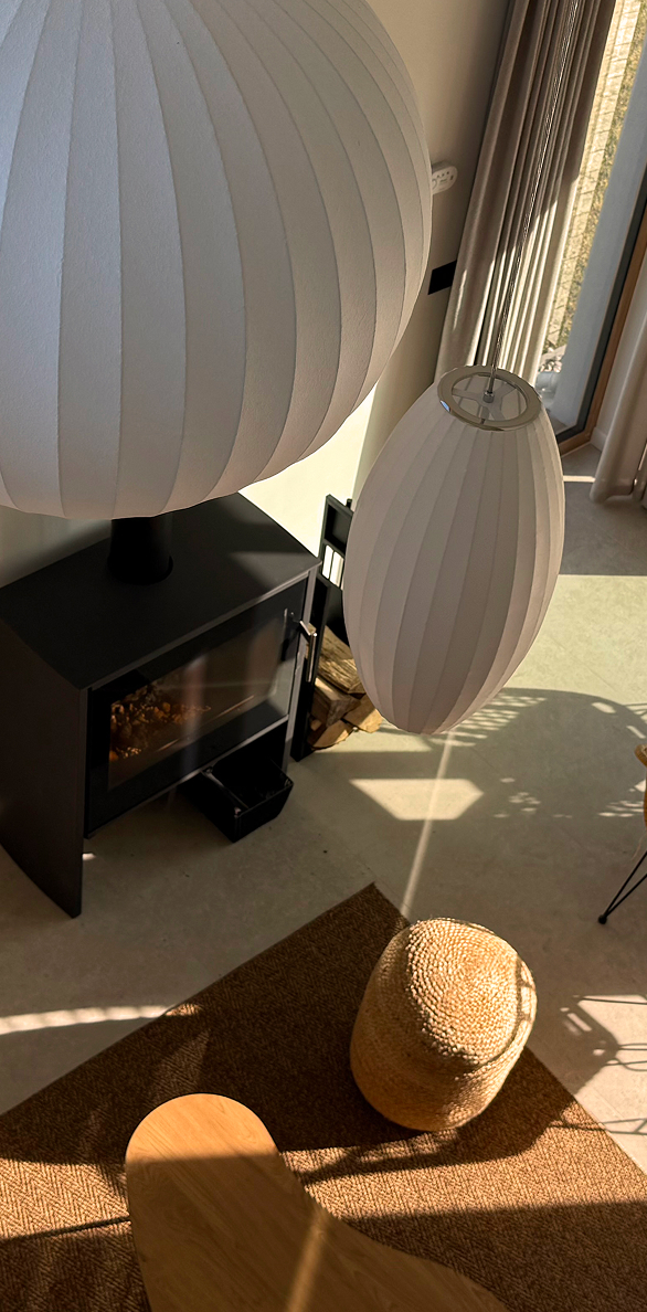 Kominek i lampa nad stołem w salonie domu MIŁO w Lubiatowie
